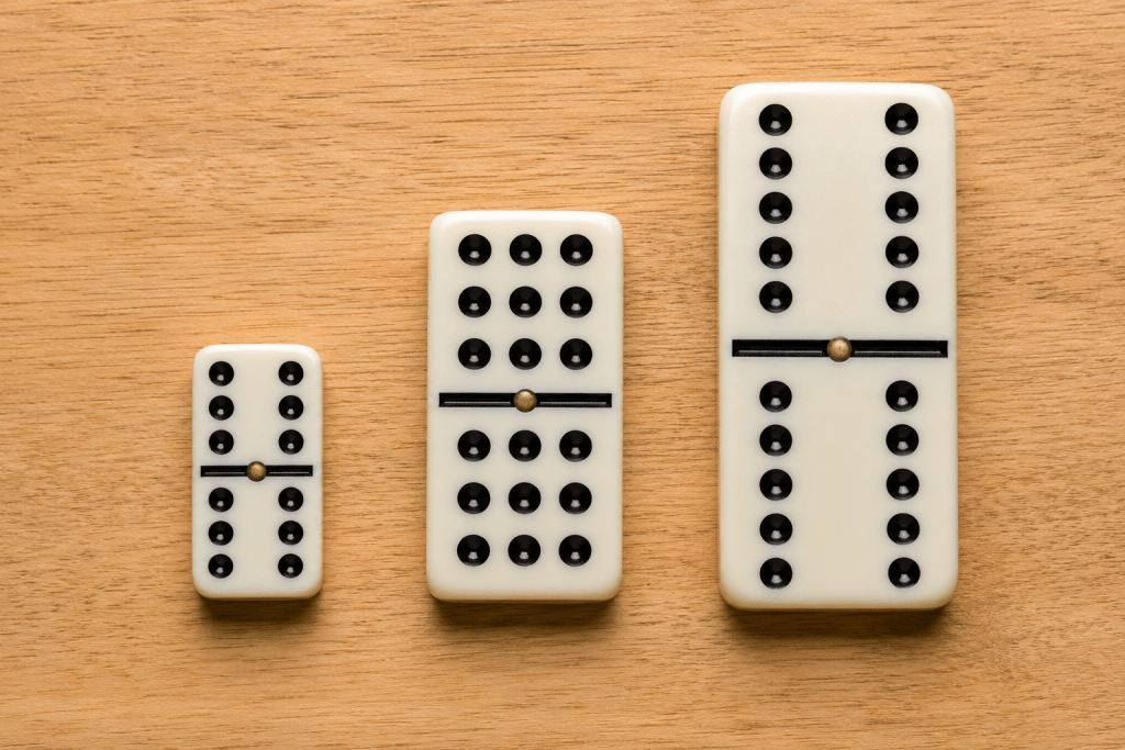 Side-by-side size comparison of a Double-6, Double-9, and Double-12 domino tile