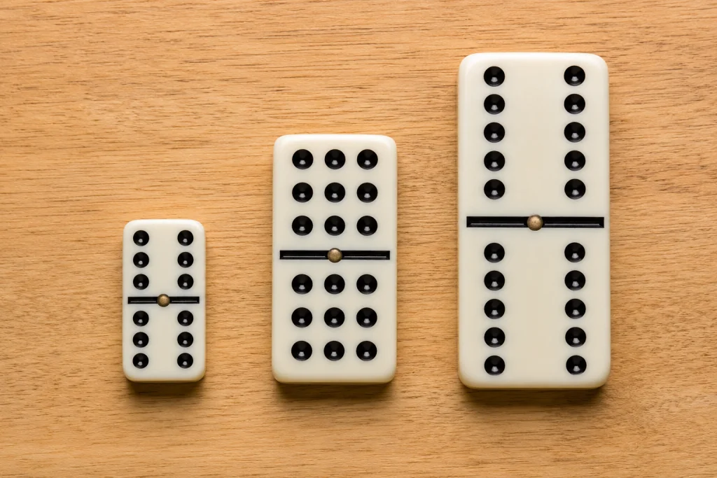Side-by-side size comparison of a Double-6, Double-9, and Double-12 domino tile
